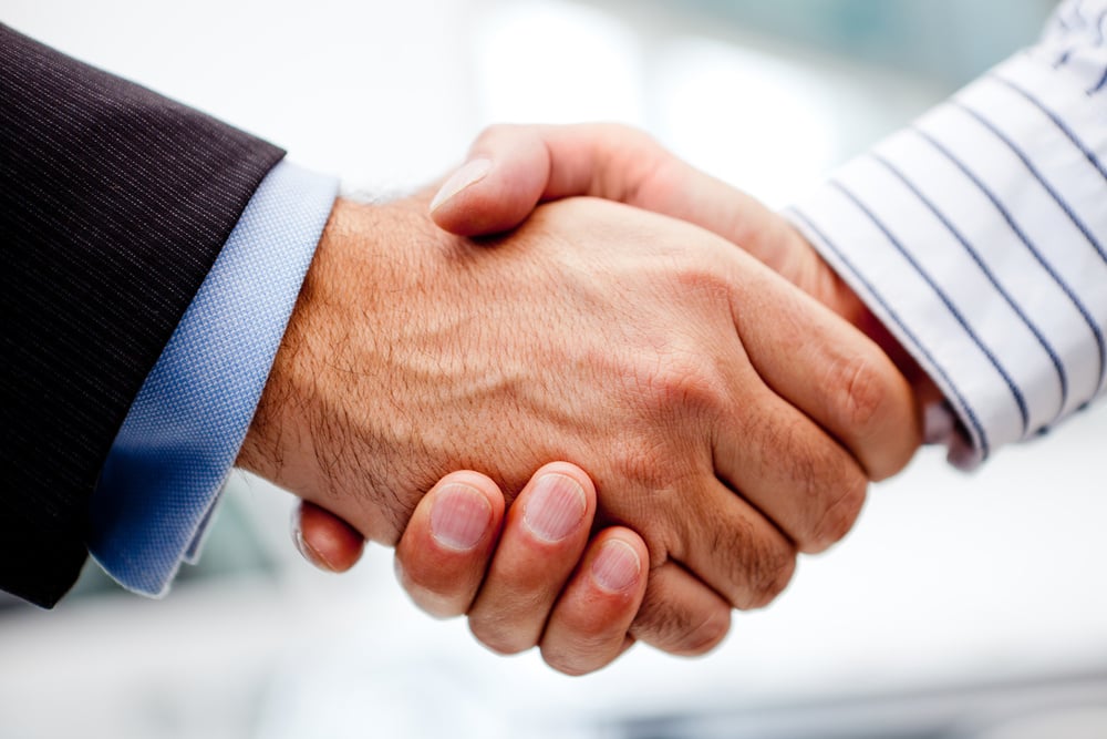 Business handshake of two men closing a deal Business handshake of two men closing a deal